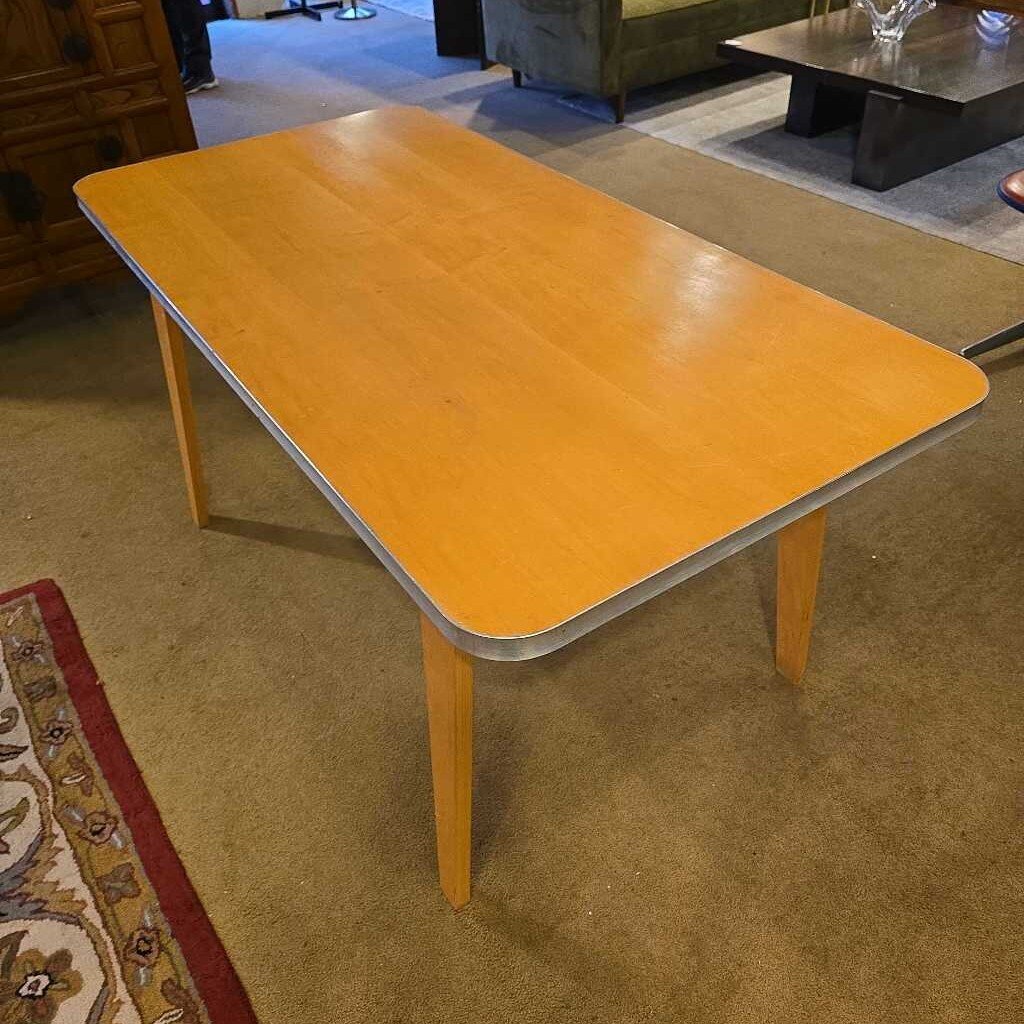 Yellow table in a room with carpeted floor and furniture.