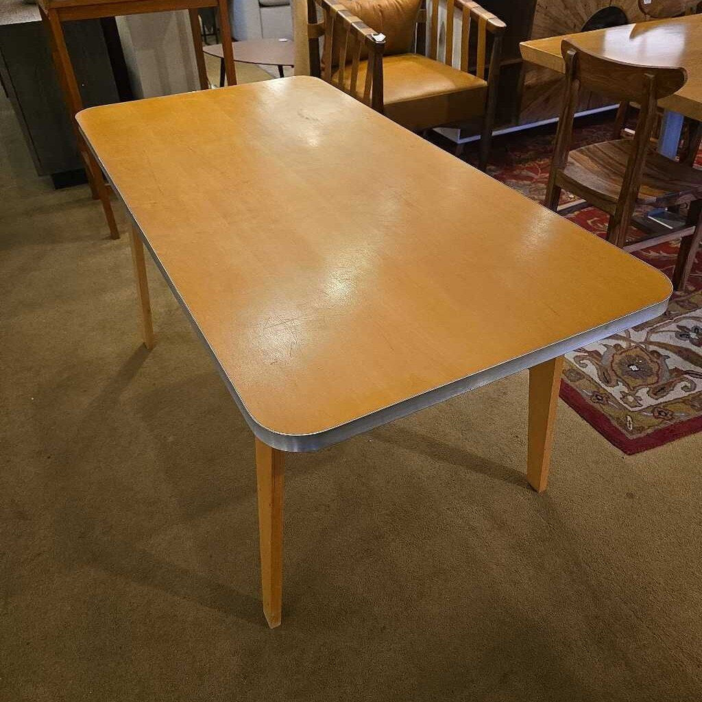 Yellow table with metal legs in a room with chairs and carpeted floor
