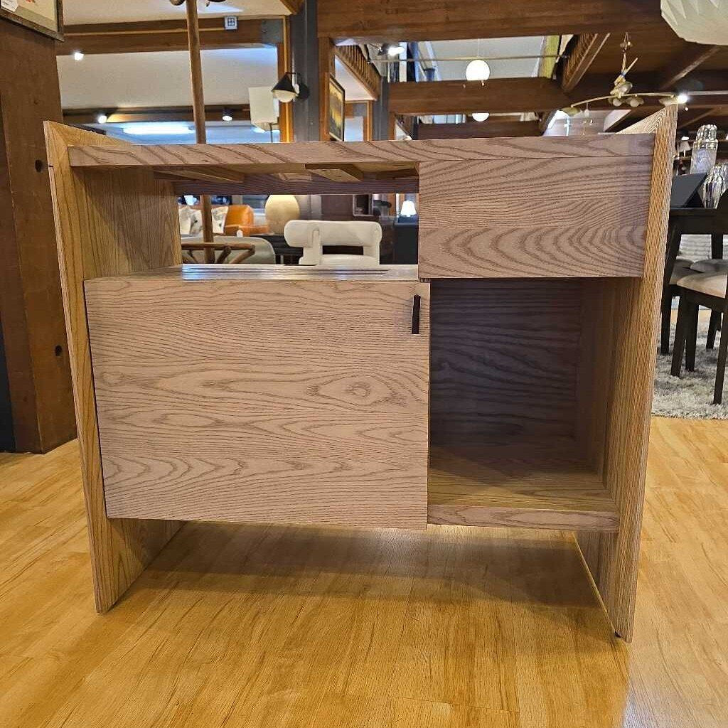 Wooden reception desk in a room with chairs and tables.