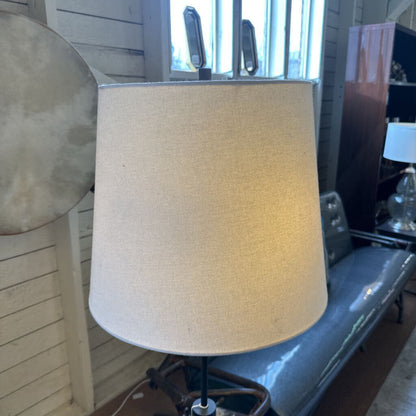 Beige lampshade on a stand with a blurred indoor background
