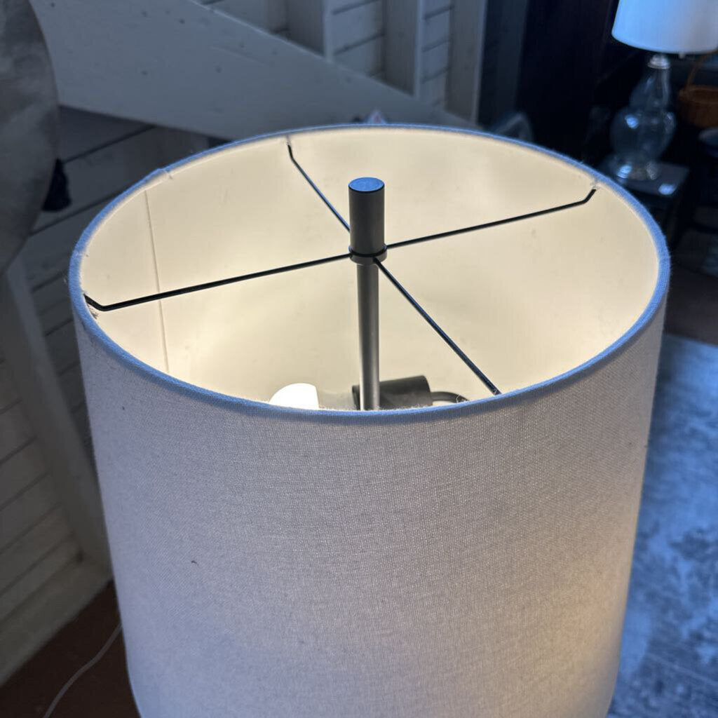 Broken lampshade with visible light inside, indoors.