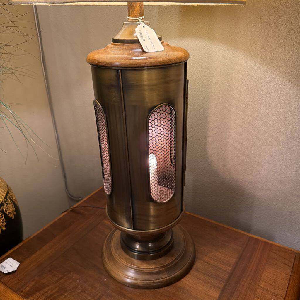 Decorative table lamp with wooden base and metallic accents on a wooden surface.