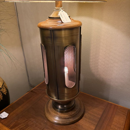 Decorative table lamp with wooden base and metallic accents on a wooden surface.