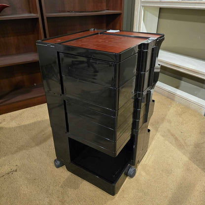 Black rolling cart with wooden top in a room setting