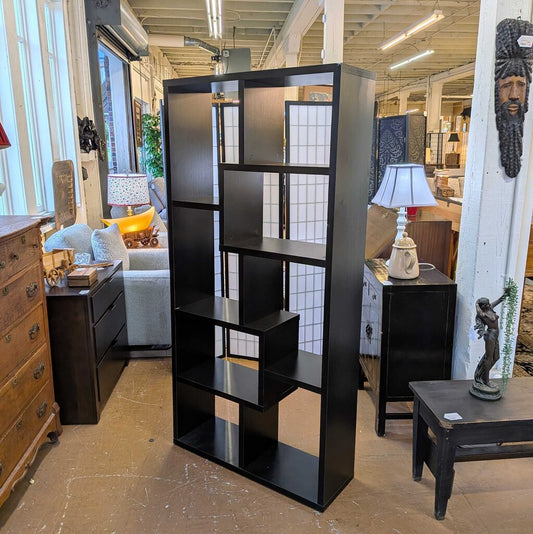 Black bookshelf in a room with furniture and decor