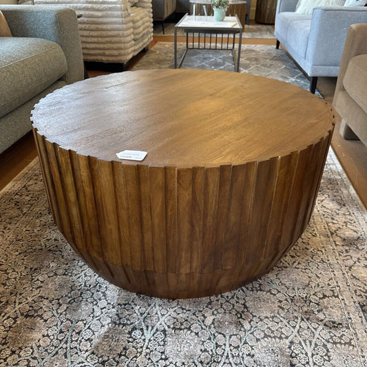 Wooden coffee table in a living room setting with furniture and decor.