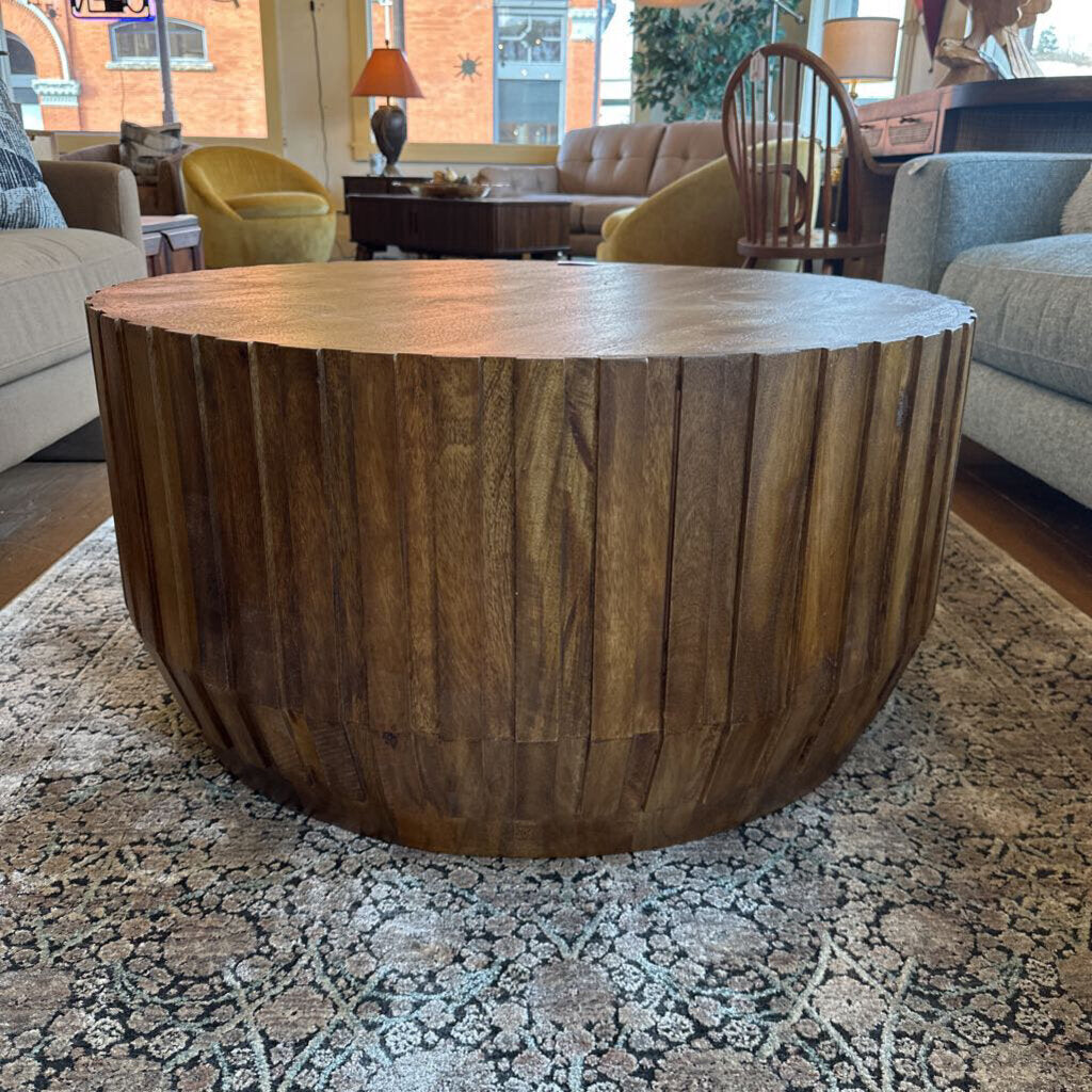 Wooden coffee table in a living room setting with furniture and decor.