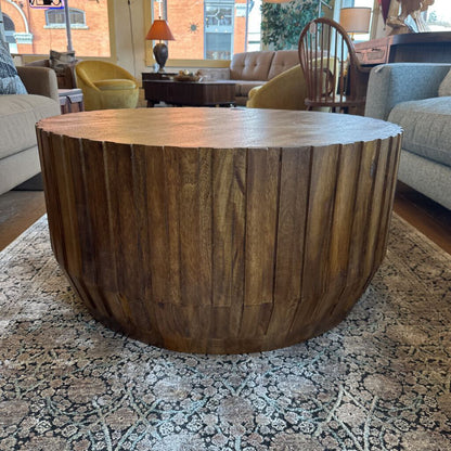 Wooden coffee table in a living room setting with furniture and decor.