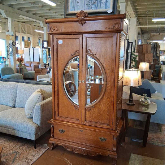 Wooden armoire with mirror in a furniture store setting