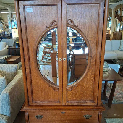Wooden cabinet with round mirror in a furniture store setting
