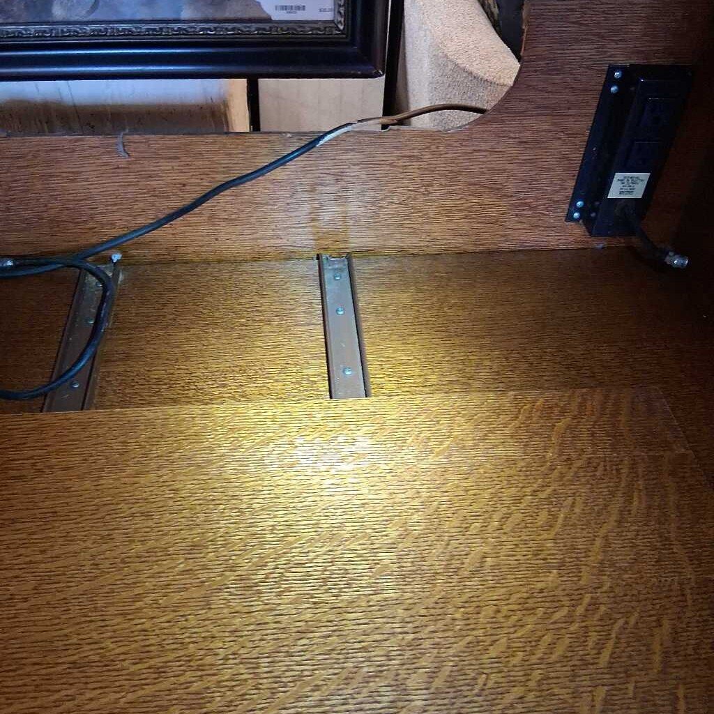 Wooden surface with a metal bracket and electrical components.