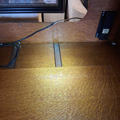 Wooden surface with a metal bracket and electrical components.