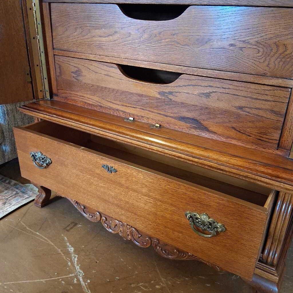 Wooden dresser with open drawer on a marble floor