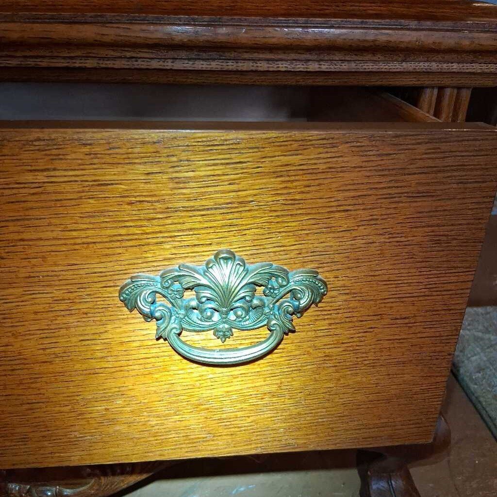 Decorative brass handle on a wooden drawer