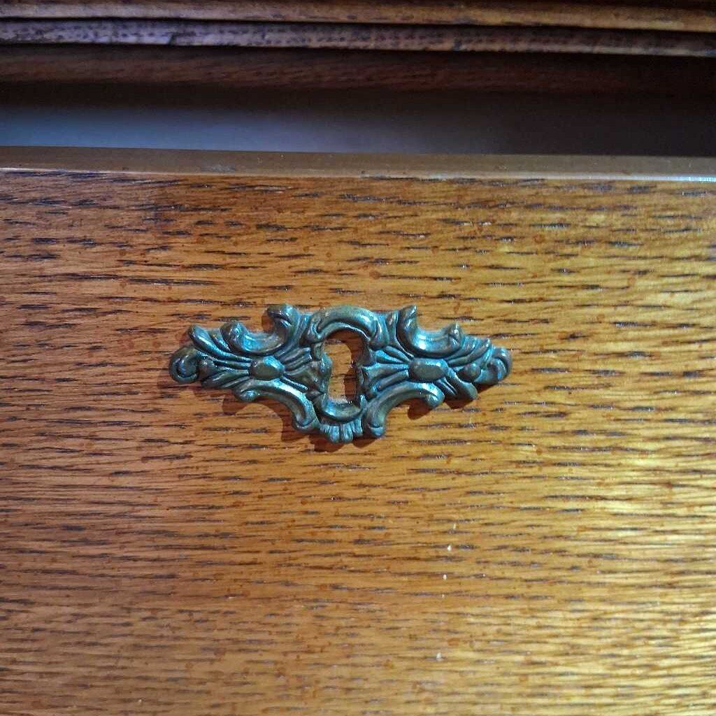 Decorative brass handle on a wooden surface