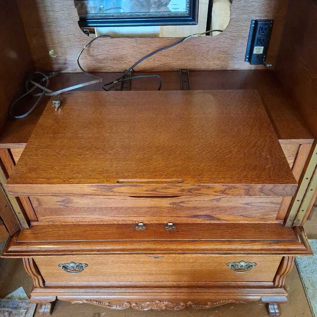 Wooden desk with a flat surface and drawers, with a pair of scissors on top.