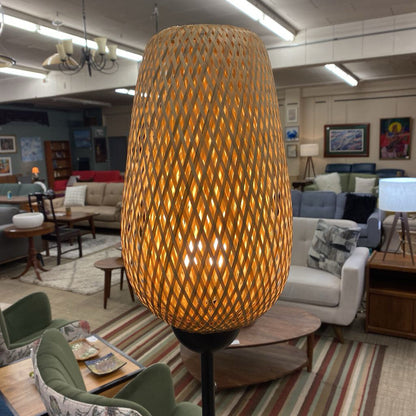 Large woven lampshade in a living room setting with furniture and decor.