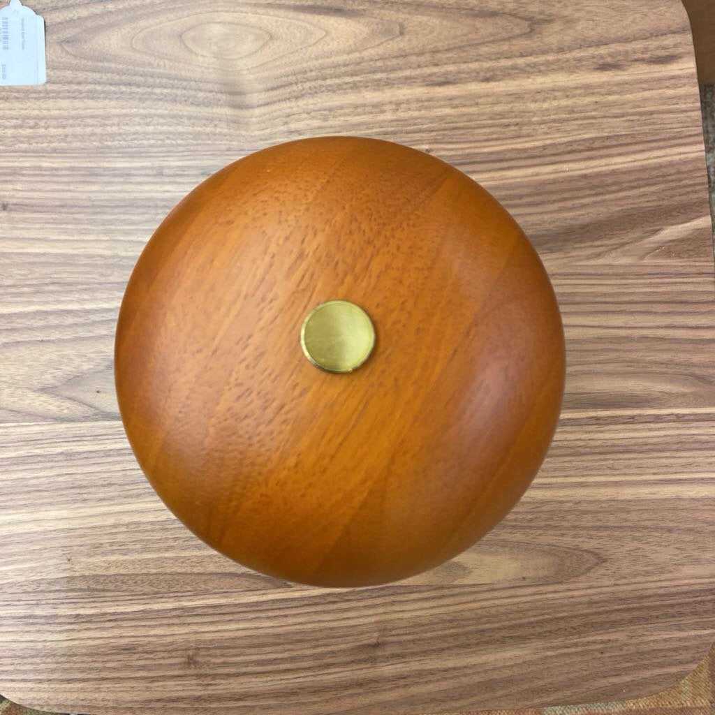 Wooden ball with a gold cap on a wooden surface