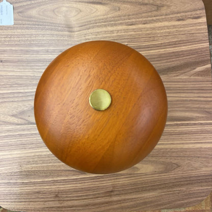Wooden ball with a gold cap on a wooden surface