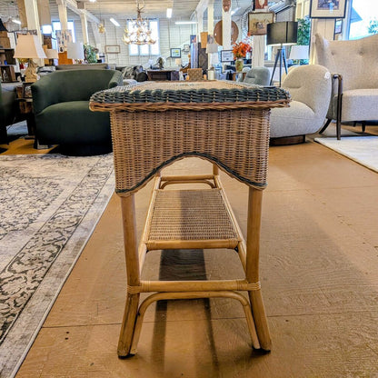 Wicker side table with a woven top and bench in a furniture store setting