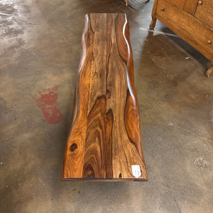 Wooden coffee table with a natural grain pattern on a concrete floor.