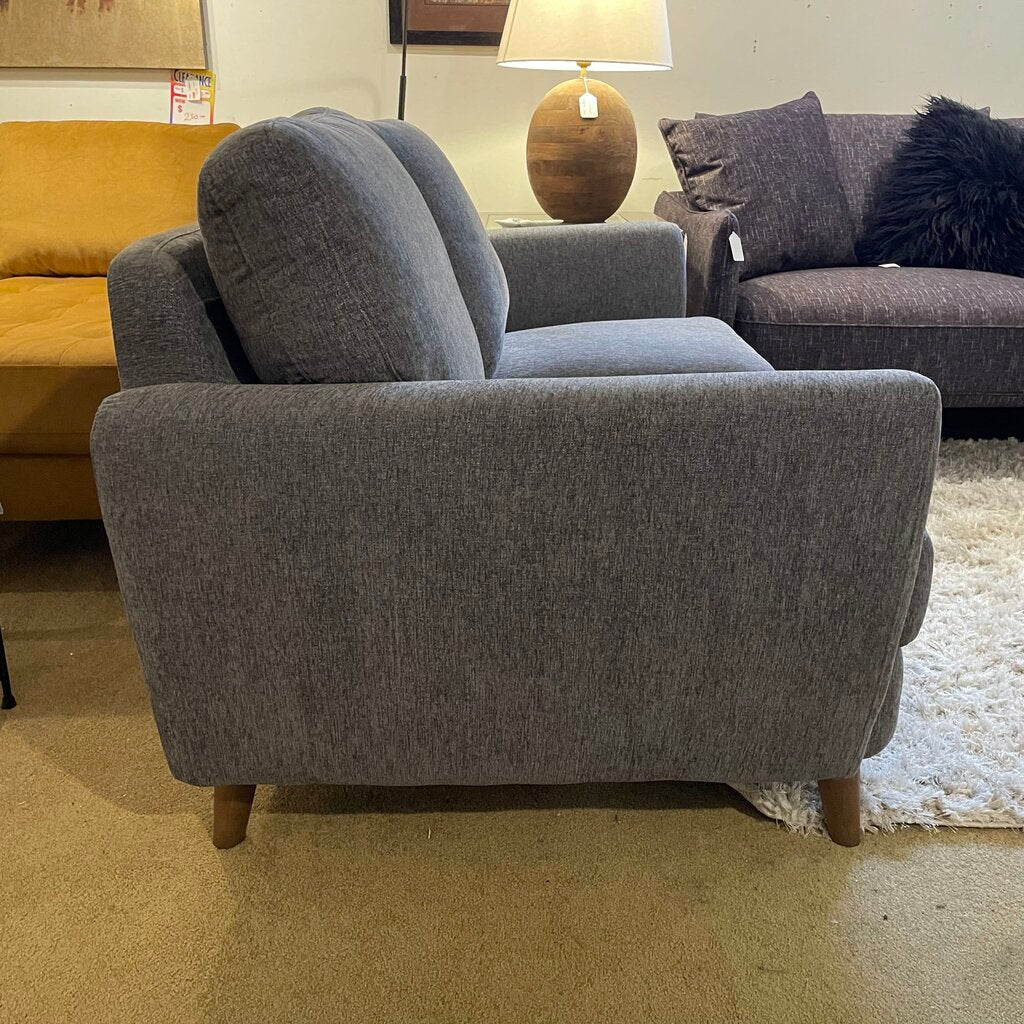 Gray sofa in a showroom with other furniture and decor items.