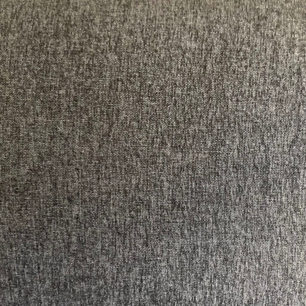 Gray sofa in a showroom with other furniture and decor items.