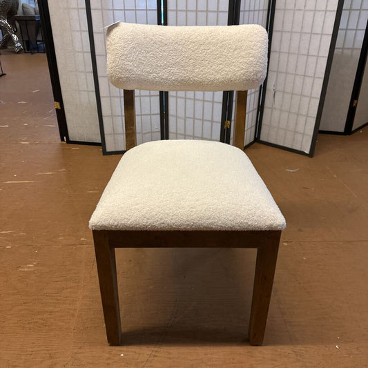Chair with white cushioned seat and backrest on a wooden floor.