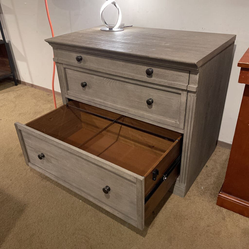 Wooden dresser with open drawer on a carpeted floor