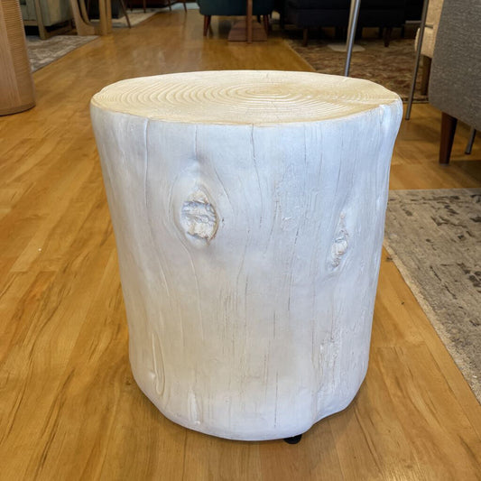 Wooden stool with a tree stump design on a wooden floor.