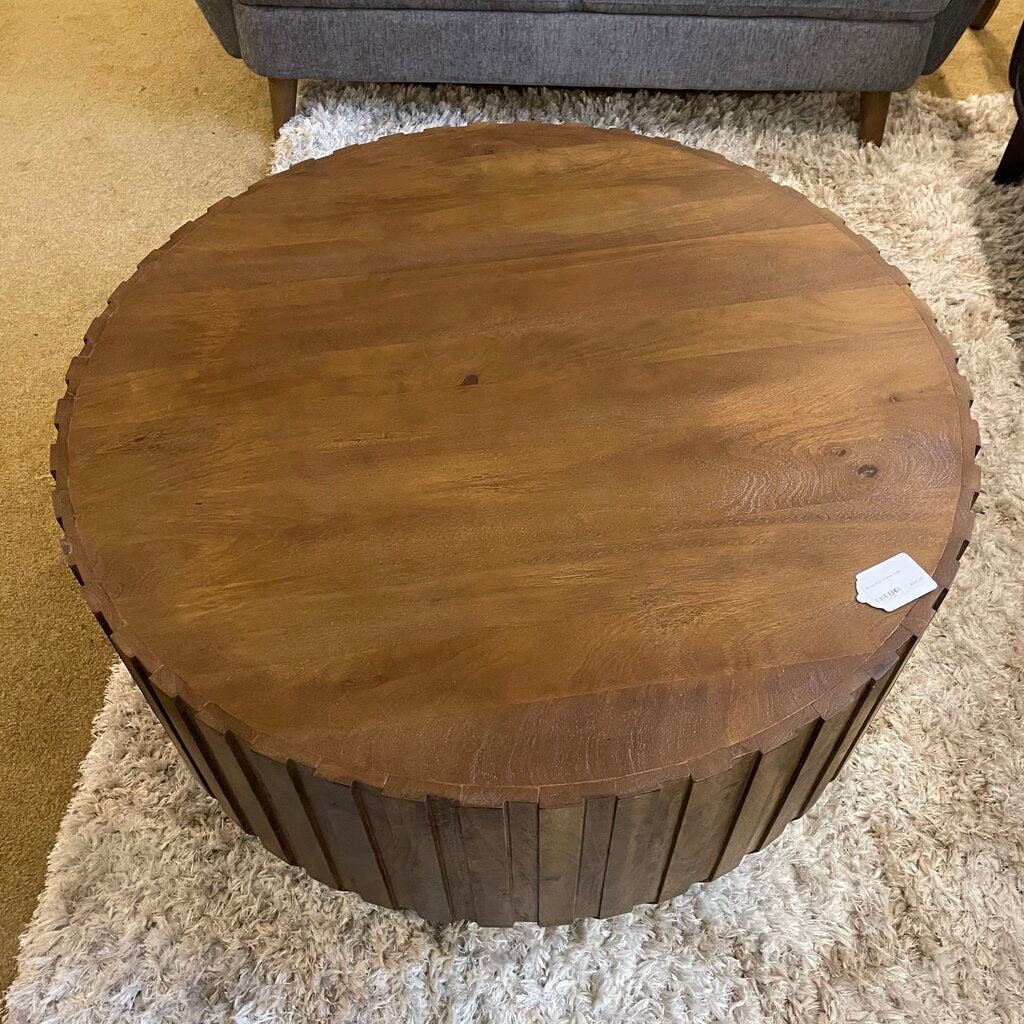 Wooden round stool on a carpeted floor with a price tag attached.
