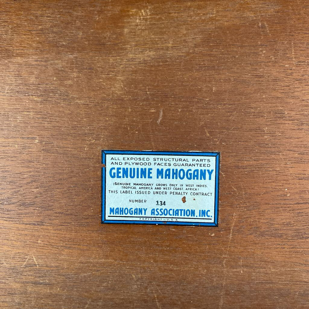 Genuine Mahogany label on a wooden surface