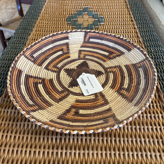 Woven basket with a tag on a wicker chair