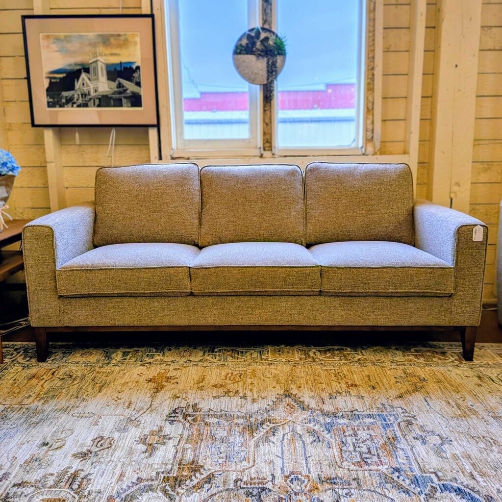 Brown sofa in a room with a window and decorative elements.