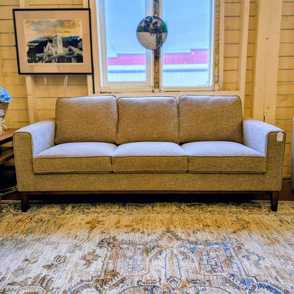 Brown sofa in a room with a window and decorative elements.