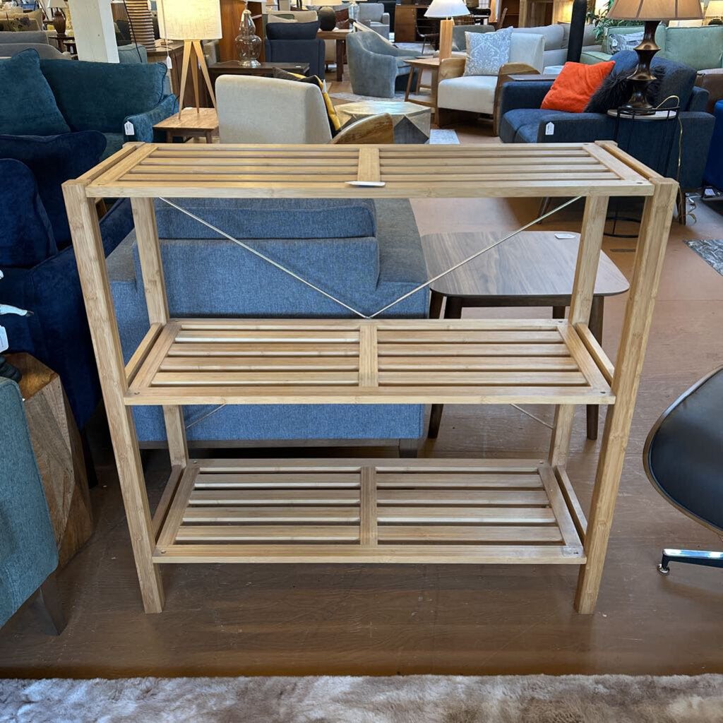 Wooden shelf in a furniture store with blue chairs and other items in the background