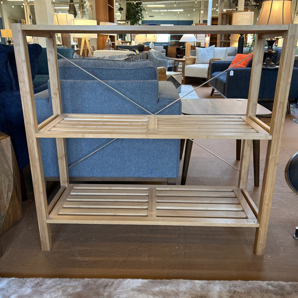 Wooden shelf in a furniture store with blue couches in the background
