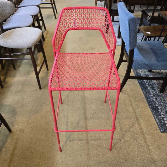 Pink metal chair among other chairs in a room setting