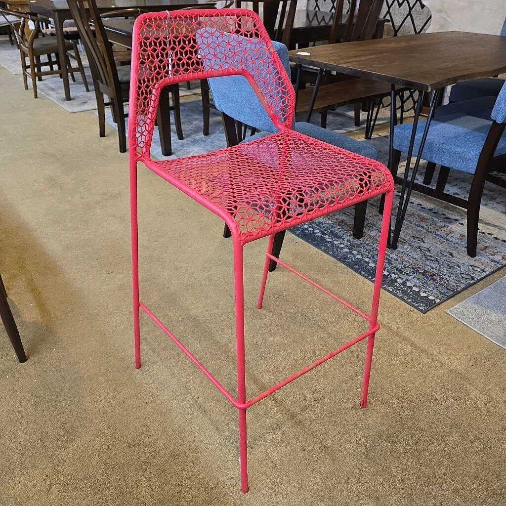 Pink metal chair in a room with tables and chairs