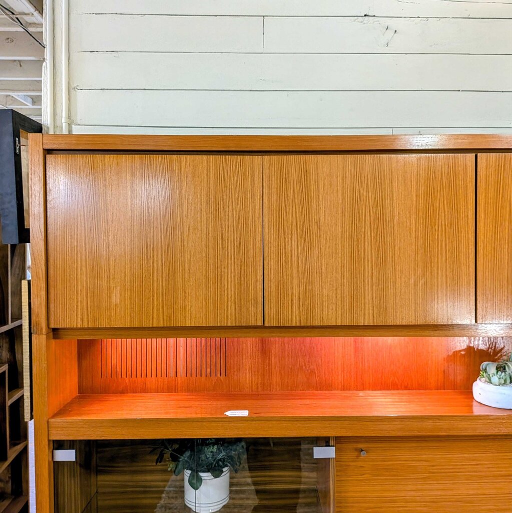 Wooden cabinet with a shelf against a white wall