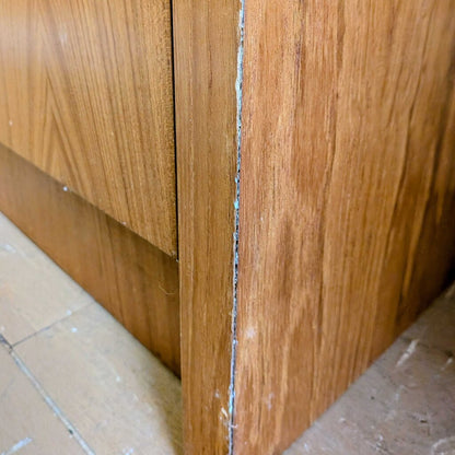 Close-up of a wooden cabinet corner with a visible gap.