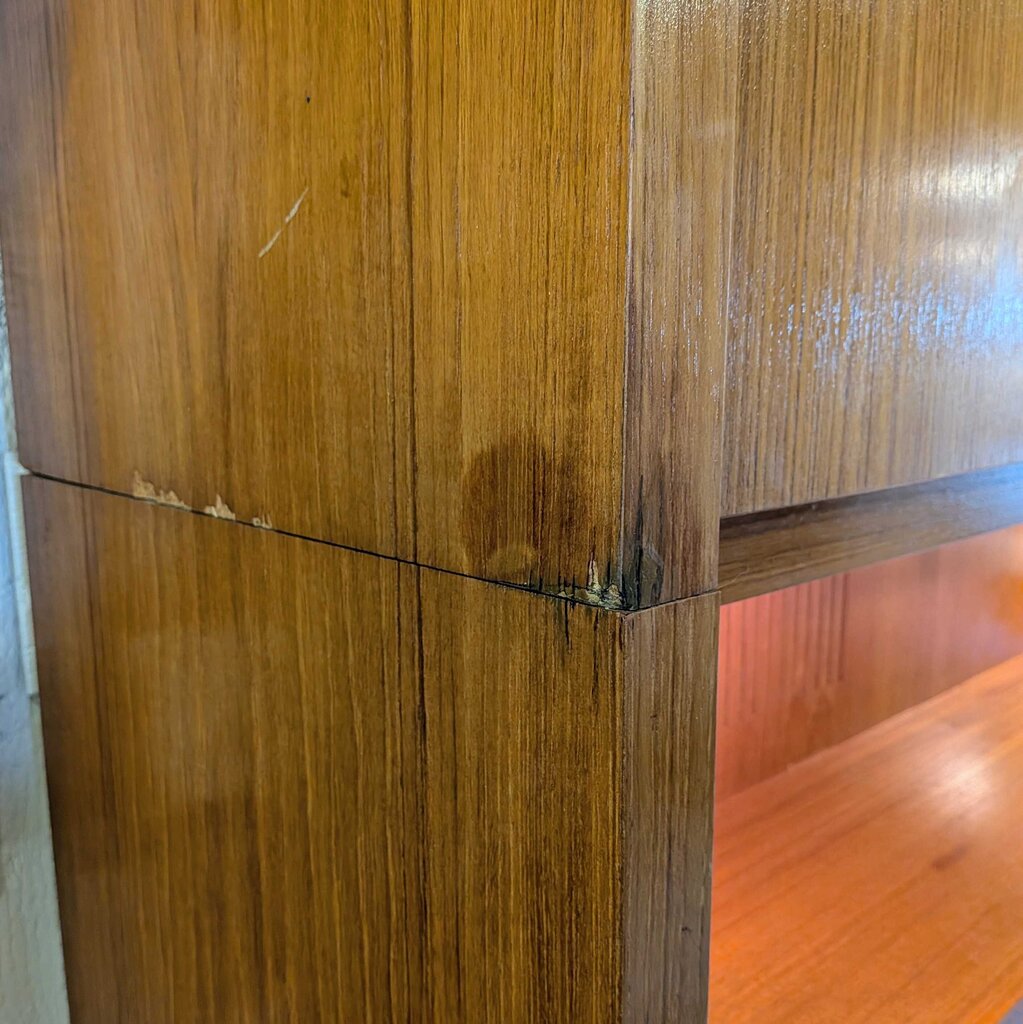 Close-up of a wooden cabinet with visible grain and a small scratch.