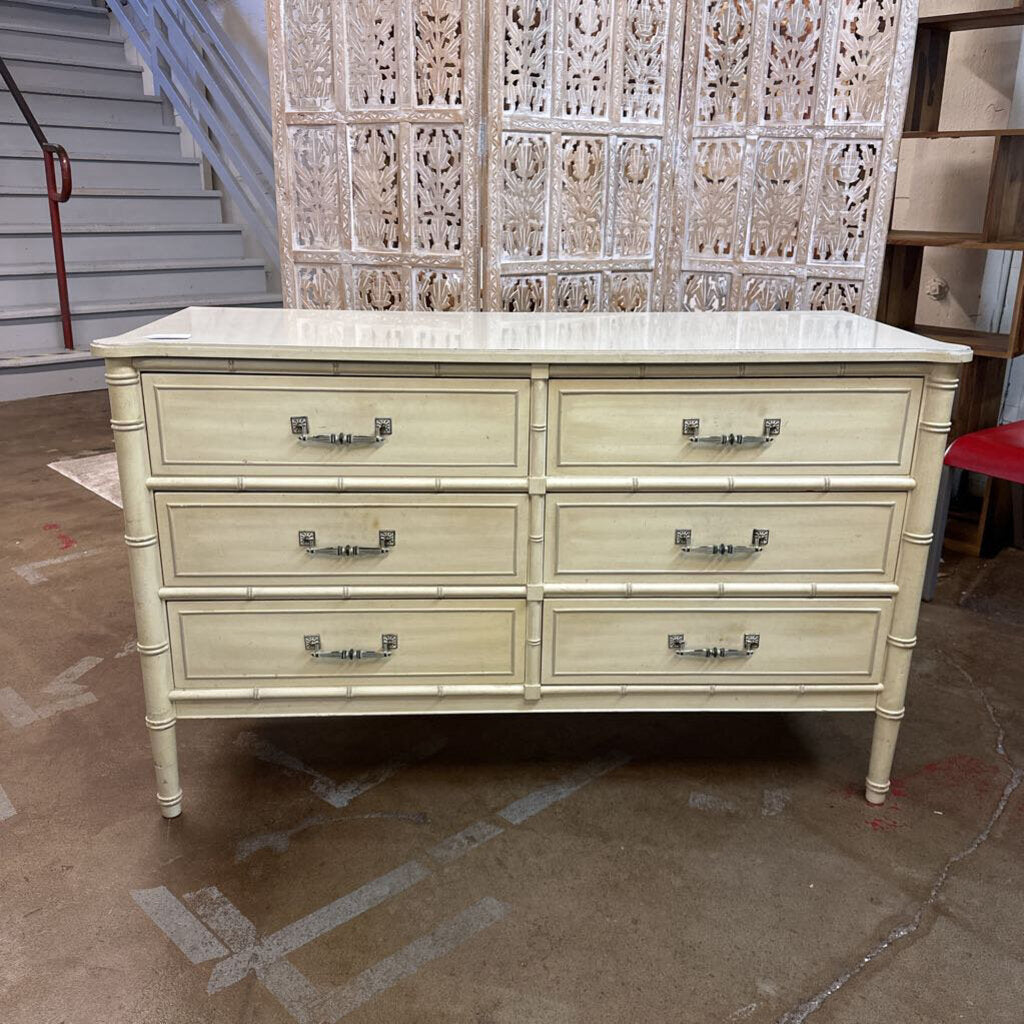 Beige dresser with marble top in a room setting