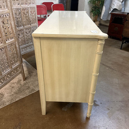 Light wooden side table with decorative legs in a room setting