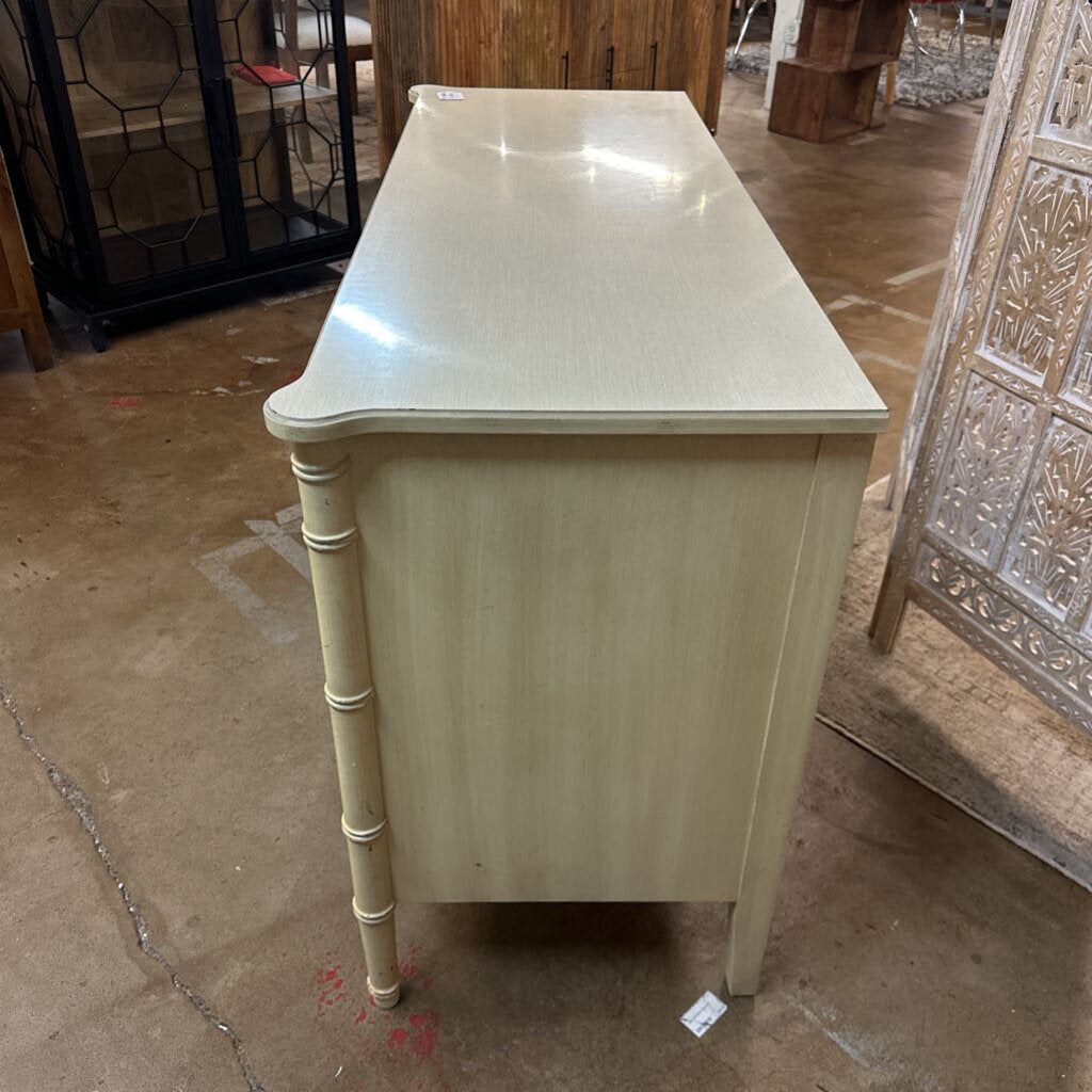 Light-colored wooden console table in a room with decorative elements.