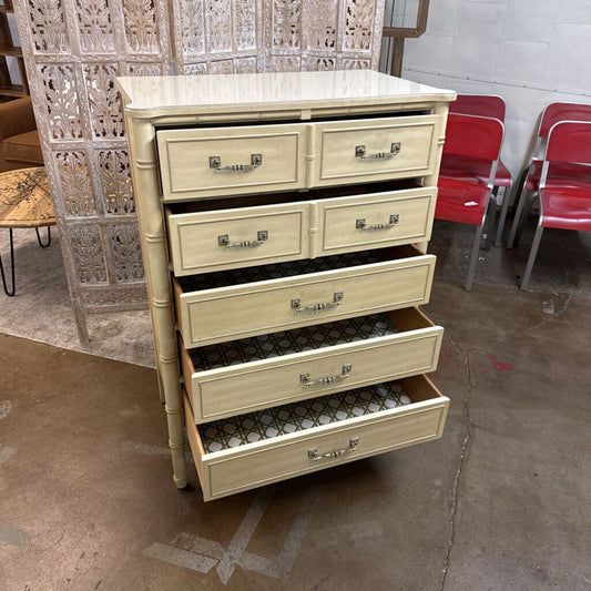 Beige dresser with multiple drawers in a room with red chairs and a decorative screen.