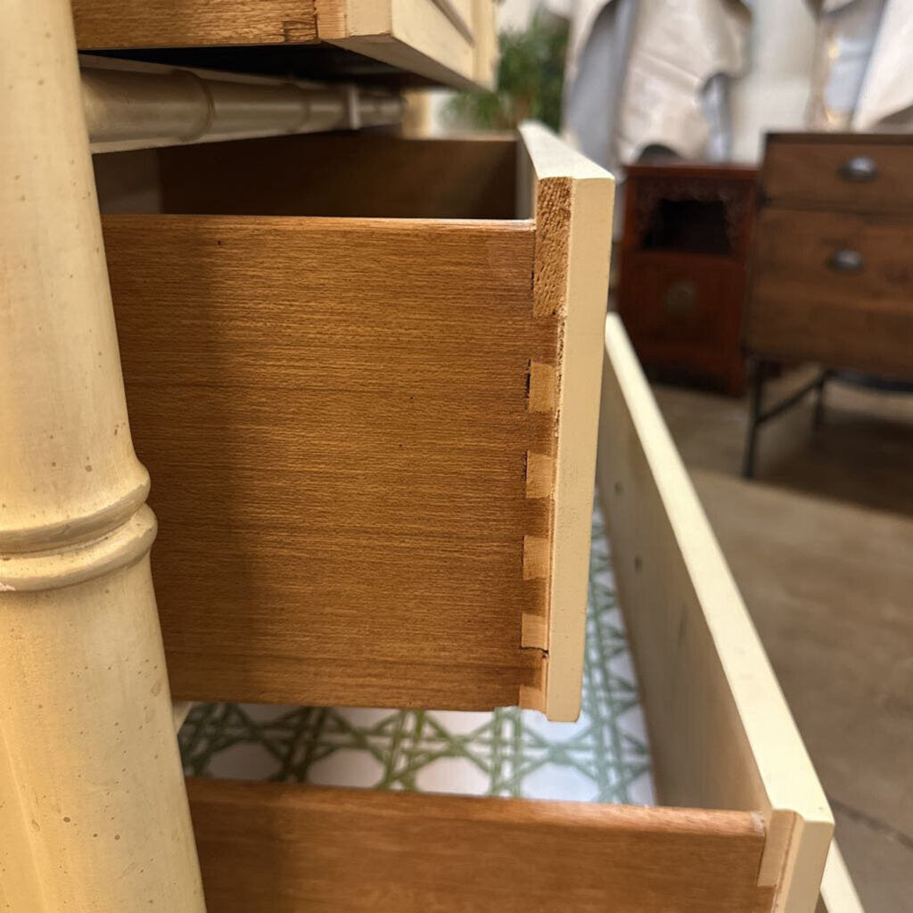 Wooden drawer being pulled out of a dresser with a blurred background