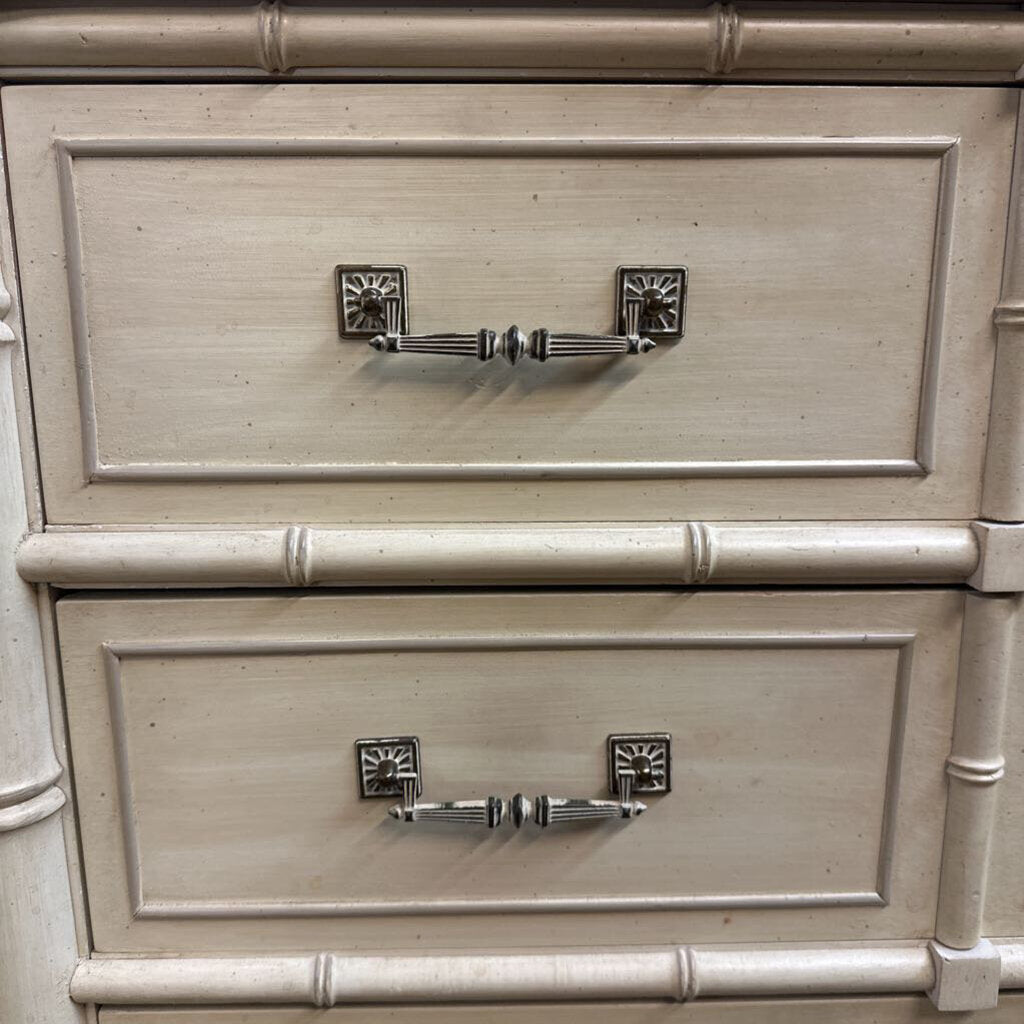 Close-up of a wooden drawer with decorative metal handles
