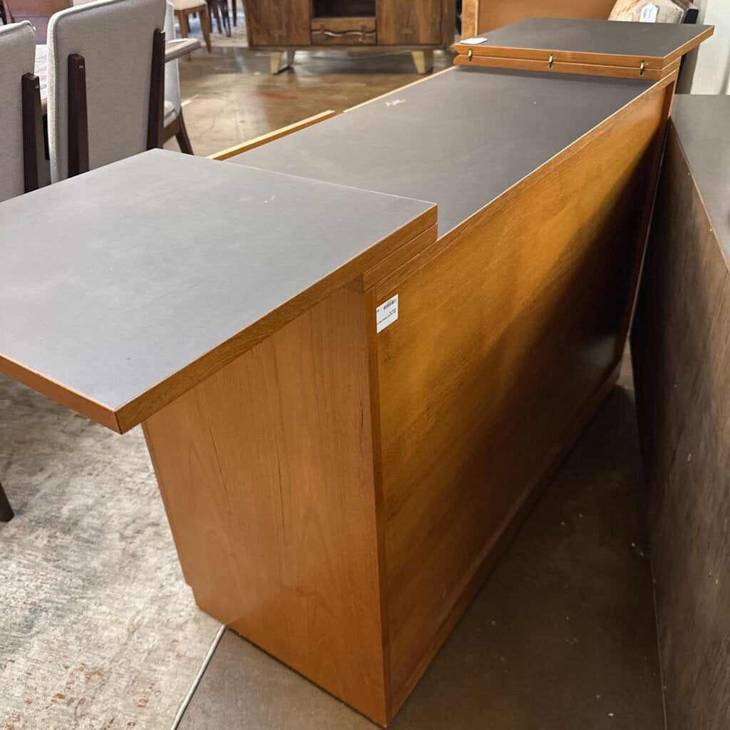 Wooden reception desk with a gray top in an indoor setting