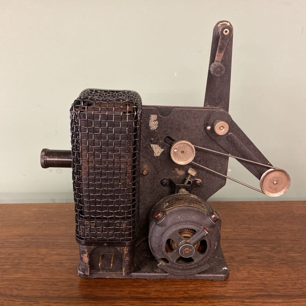 Vintage metal machine on a wooden surface with a plain background